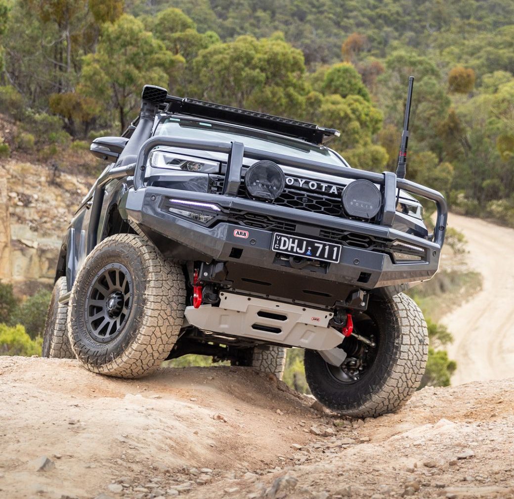 4WD fitted with a bull bar climbing a rocky Australian bush track