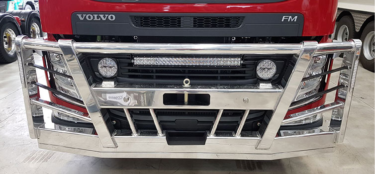Polished truck bull bar with LED light bar on a red Volvo FM